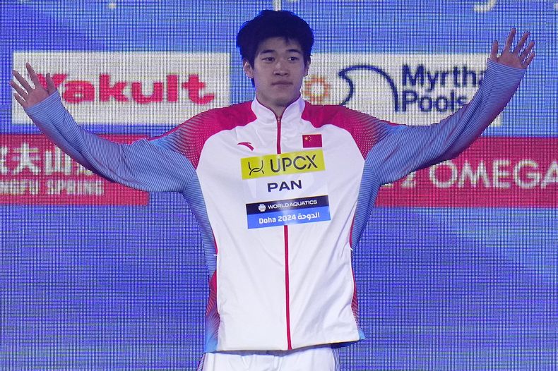 El chino Zhanle Pan celebra en e podio tras ganar la medalla de oro en la final de los 100 metros libres en el Campeonato Mundial de Natación en Doha, Qatar el jueves 15 de febrero del 2024. (AP Foto/Hassan Ammar)