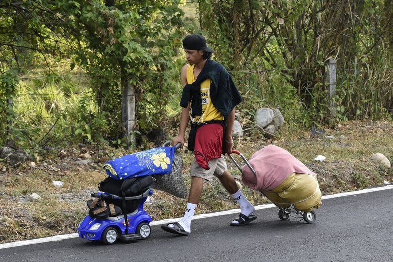 Un migrante carga las pertenencias de su familia durante su caminata hacia el norte como parte de la caravana de migrantes que avanza por la autopista en Villa Comaltitlán, en el estado de Chiapas, al sur de México, el miércoles 27 de diciembre de 2023. (AP Foto/Édgar H. Clemente)