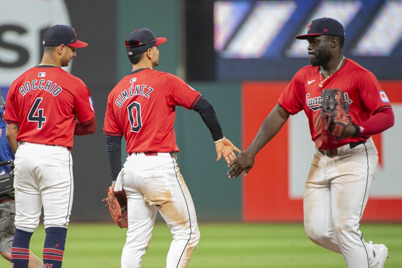 Andrés Giménez (0), de los Guardianes de Cleveland, saluda a Jhonkensy Noel, a la derecha, mientras Brayan Rocchio (4) observa al final de un juegocontra los Rangers de Texas en Cleveland, el sábado 24 de agosto de 2024. (AP Foto/Phil Long)