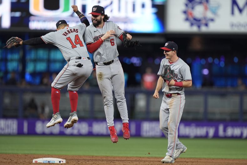 El segunda base de los Nacionales de Washington, Ildemaro Vargas (14), el jardinero izquierdo Jesse Winker (6) y el jardinero central Jacob Young celebran después de que los Nacionales vencieron 12-9 a los Marlins de Miami en un juego de béisbol, el domingo 28 de abril de 2024, en Miami. (AP Foto/Wilfredo Lee)