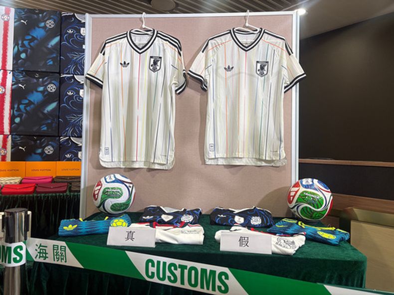 Autoridades aduaneras de Hong Kong muestran equipaciones de fútbol reales, a la izquierda, y falsificaciones, a la derecha, durante una conferencia de prensa en su sede en North Point, Hong Kong, el jueves 11 de junio de 2026. (AP Foto/Kanis Leung)