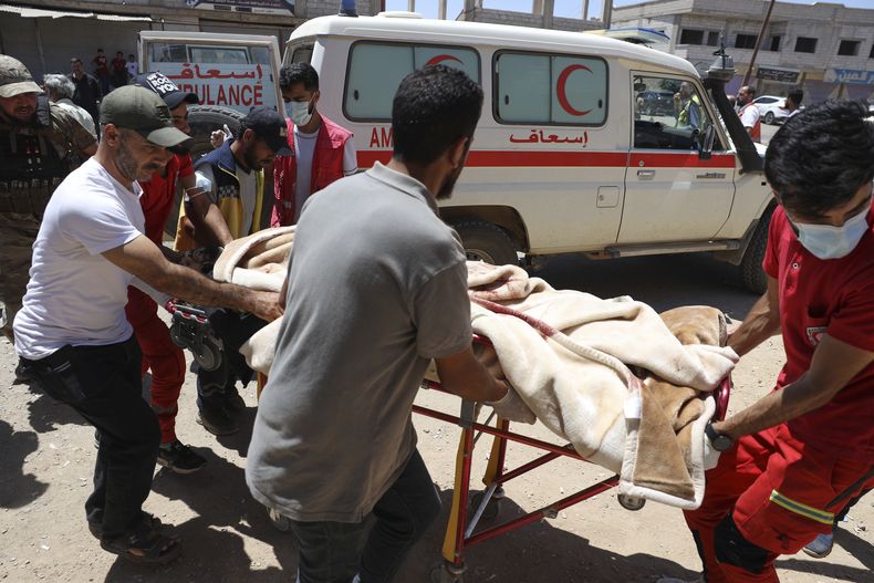 Voluntarios de la Media Luna Roja se llevan a un soldado oficialista herido durante choques entre las fuerzas oficialistas y milicias drusas en ua clínica en la aldea de Busra al-Harir en el sur de Siria el 15 de julio del 2025. (AP foto/Omar Albam)