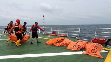 En esta imagen, distribuida por la Agencia Nacional de Búsqueda y Rescate de Indonesia, BASARNAS, rescatistas trasladan el cuerpo de una víctima del naufragio de un transbordador enn un barco de la agencia, en el mar de Java, Indonesia, el 25 de septiembre de 2026. (BASARNAS vía AP)