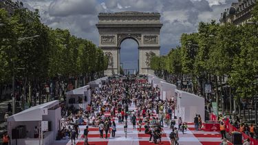 La gente almuerza durante un picnic gigante organizado en Campos Elíseos, frente al Arco de Triunfo, el domingo 26 de mayo de 2024 en París, Francia. (Foto AP/Aurelien Morissard)
