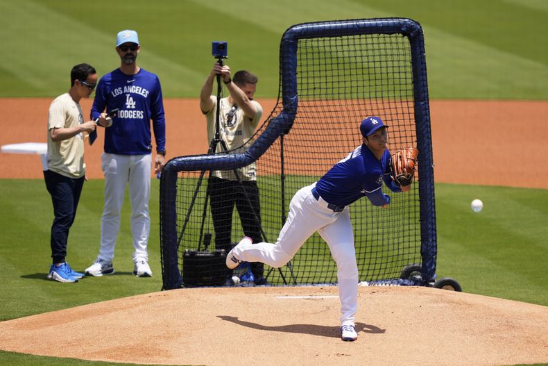 El lanzador de los Dodgers de Los Ángeles, Shohei Ohtani, al centro, lanza una práctica de bateo en vivo mientras el coach de lanzadores Mark Prior, segundo desde la izquierda, observa antes de un juego de béisbol contra los Yankees de Nueva York, el sábado 31 de mayo de 2025, en Los Ángeles. (Foto AP/Mark J. Terrill)