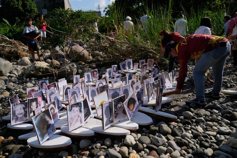 Familiares de niños desaparecidos desde la erupción del Nevado del Ruiz se preparan para lanzar pequeñas embarcaciones con fotos de los niños desaparecidos al río Guali en Honda, Colombia, el miércoles 12 de noviembre de 2025, en vísperas del 40 aniversario del desastre que cobró la vida de aproximadamente 25.000 personas. (Foto AP/Fernando Vergara)