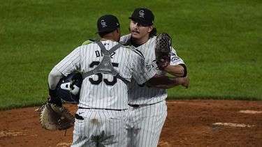 El receptor venezolano de los Rockies de Colorado, Elías Díaz (al frente), felicita al relevista Victor Vodnik luego del juego de béisbol ante los Mets de Nueva York, el martes 6 de agosto de 2024, en Denver. (AP Foto/David Zalubowski)