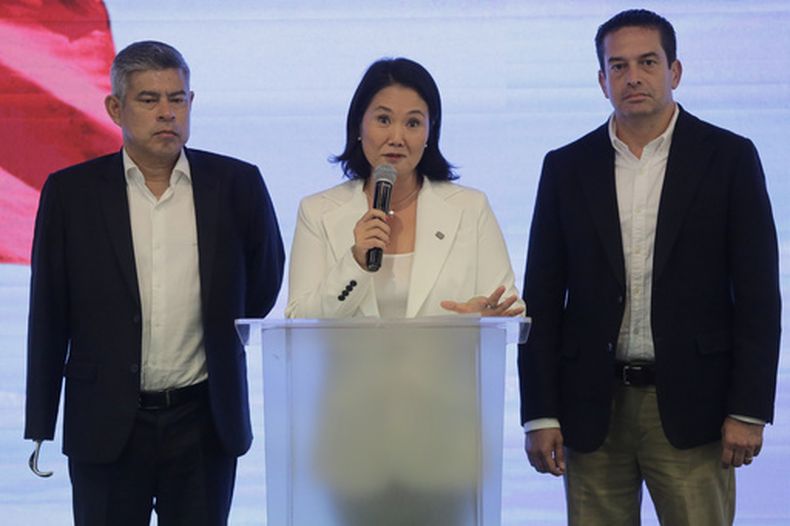 Keiko Fujimori, candidata presidencial del partido Fuerza Popular, habla flanqueada por los candidatos al Congreso Luis Galarreta, a la izquierda, y Micky Torres, a la derecha, tras el cierre de las urnas en las elecciones generales en Lima, Perú, el domingo 12 de abril de 2026. (AP Foto/Gerardo Marin)