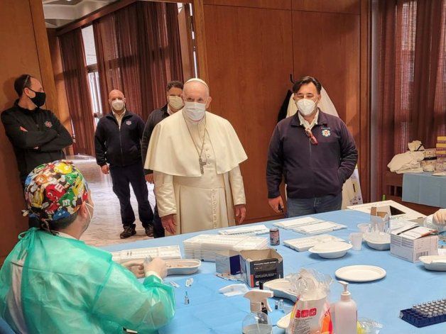 El Papa Francisco conversa con personal médico durante una visita en Viernes Santo a un centro de vacunación para personas sin hogar en el Vaticano (Vatican Media/Handout via REUTERS)