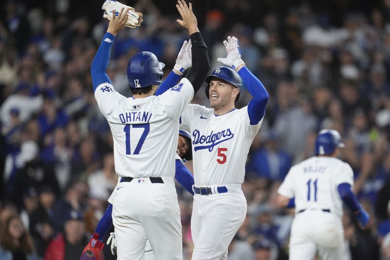 Freddie Freeman (5), de los Dodgers de Los Ángeles, celebra después de batear un grand slam con su compañero Shohei Ohtani (17) durante la tercera entrada del juego de béisbol en contra de los Diamondbacks de Arizona, el lunes 20 de mayo de 2024, en Los Ángeles. (AP Foto/Marcio Jose Sanchez)