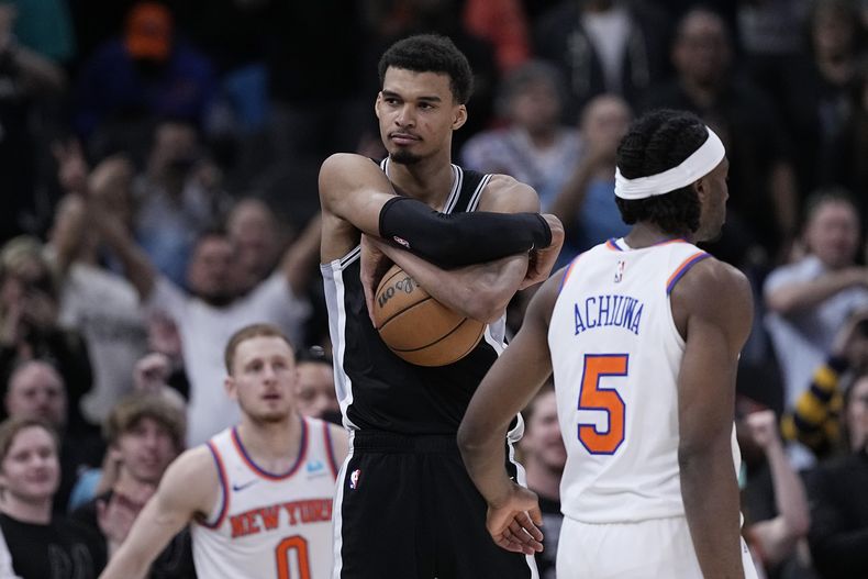 El francés Victor Wembanyama, de los Spurs de San Antonio, abraza el balón, al asegurar el triunfo sobre los Knicks de Nueva York, el viernes 29 de marzo de 2024 (AP Foto/Eric Gay)