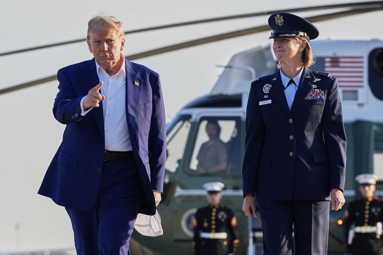 El presidente estadounidense, Donald Trump, izquierda, escoltado por la coronela de la Fuerza Aérea, Angela F. Ochoa, comandante de la 89na Unidad de Transporte Aéreo, camina del Marine One para abordar el Air Force One, el martes 24 de junio de 2025, en la Base Conjunta Andrews, Maryland. (AP Foto/Alex Brandon)