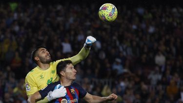 El arquero Rui Silva (izquierda) del Betis despeja el balón frente a Robert Lewandowski del Barcelona en el partido de la Liga española, el sábado 29 de abril de 2023, en Barcelona. (AP Foto/Joan Monfort)