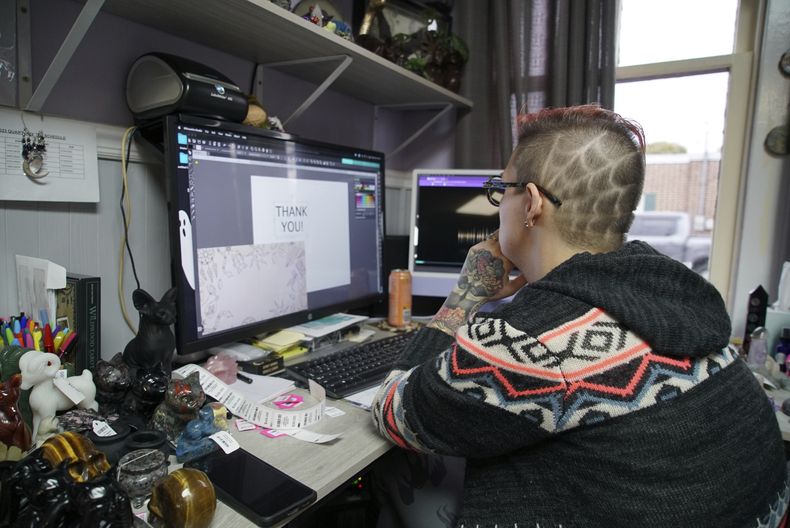 Melissa Sell usa su computadora para trabajar en el inventario de su tienda Every Witch Way, el lunes 30 de octubre de 2023, en Mount Holly Springs, Pensilvania. Sell dijo creer que el nivel de desconfianza es ahora tan elevado que podría producirse una guerra civil o alguna otra clase de alzamiento popular, pero que sería el gobierno el que lo inicie. (AP Foto/Allen G. Breed)