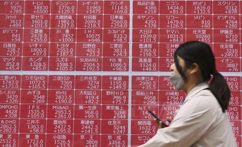 Una persona pasa por delante de una pantalla con cotizaciones en una empresa bursátil, en Tokio, el 10 de abril de 2025. (Kyodo News vía AP)