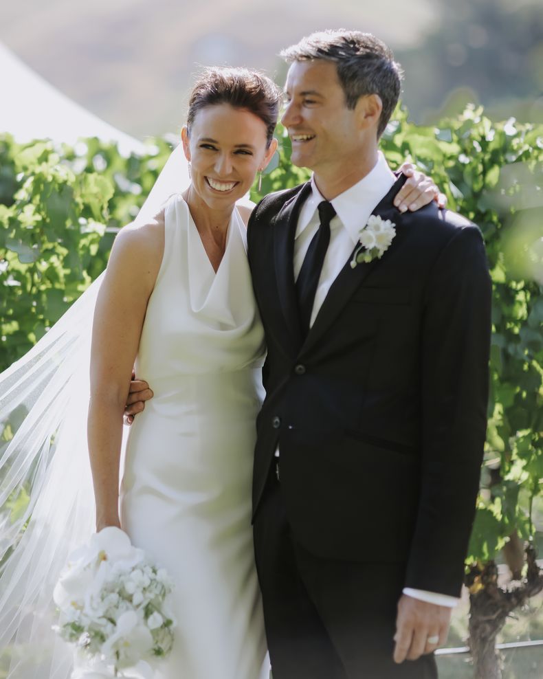 En esta foto distribuida por Jacinda Ardern y Clarke Gayford, la ex primera ministra de Nueva Zelanda, Jacinda Ardern abraza a su esposo Clarke Gayford en su boda en Havelock North, Nueva Zelanda, sábado 13 de enero de 2024. Después de cinco años de compromiso y un aplazamiento debido a la pandemia de coronavirus, Ardern y su pareja se casaron en una ceremonia íntima en en el norte del país. (Felicity Jean Photography via AP)