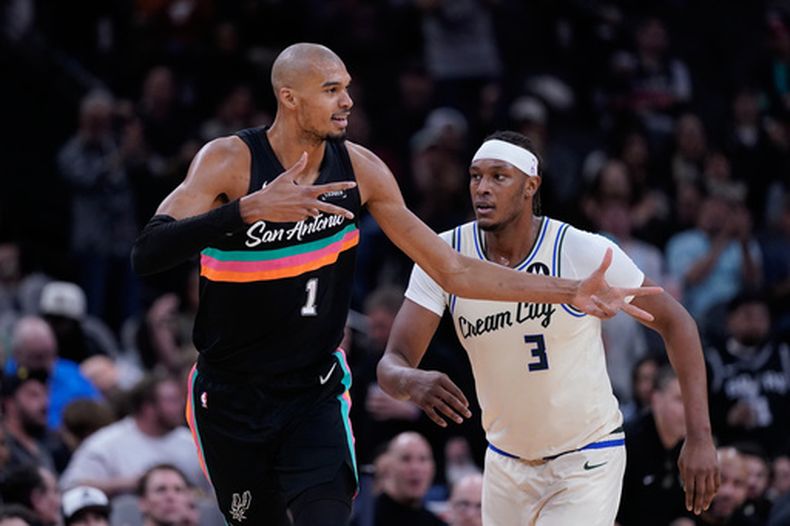 Victor Wembanyama, alero de los Spurs de San Antonio, festeja un enceste frente a Myles Turner, de los Bucks de Milwaukee, en el encuentro del jueves 15 de enero de 2026 (AP Foto/Eric Gay)