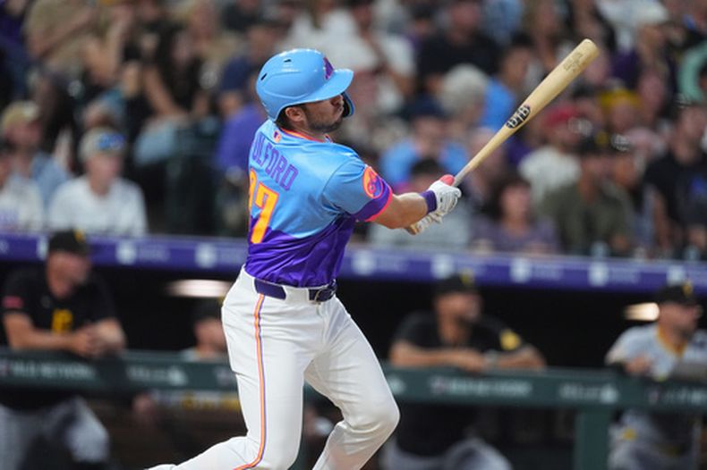 El bateador emergente de los Rockies de Colorado, Braxton Fulford, sigue la trayectoria de su doblete productor de dos carreras ante el lanzador de relevo de los Piratas de Pittsburgh, Mason Montgomery, en la octava entrada de un partido de béisbol el viernes 19 de junio de 2026, en Denver. (Foto AP/David Zalubowski)