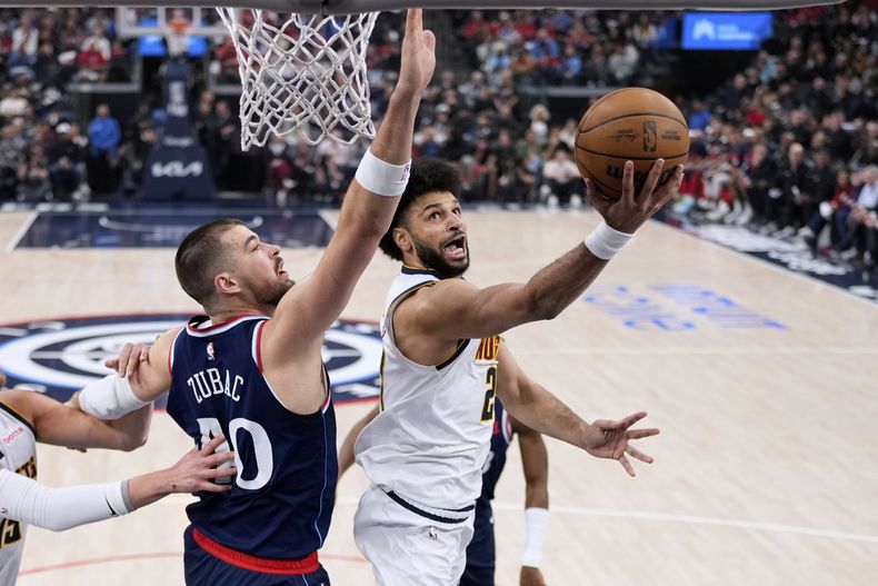 El escolta de los Nuggets de Denver, Jamal Murray, a la derecha, dispara mientras el pívot de los Clippers de Los Ángeles, Ivica Zubac, defiende durante la primera mitad del Juego 4 de una serie de playoffs de primera ronda de baloncesto de la NBA, el sábado 26 de abril de 2025, en Inglewood, California (AP Foto/Mark J. Terrill)