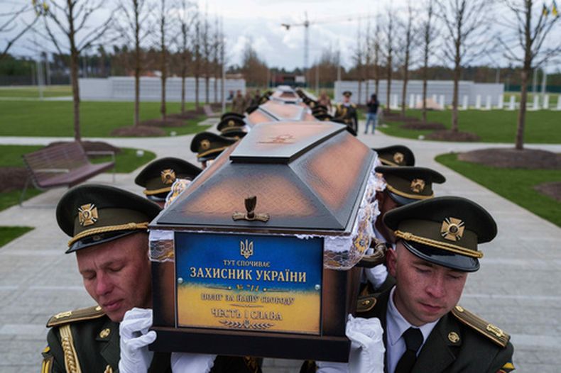 ARCHIVO - Una guardia de honor cargan con los féretros de soldados ucranianos no identificados muertos en batalla durante la guerra entre Rusia y Ucrania en un funeral en un cementerio militar cerca de Kiev, Ucrania, el 30 de abril de 2026. (AP Foto/Evgeniy Maloletka, archivo)