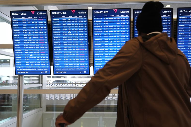 Un viajero observa una pantalla de itinerarios el domingo 9 de noviembre de 2025, en el Aeropuerto Internacional de Detroit. (AP Foto/Ryan Sun)