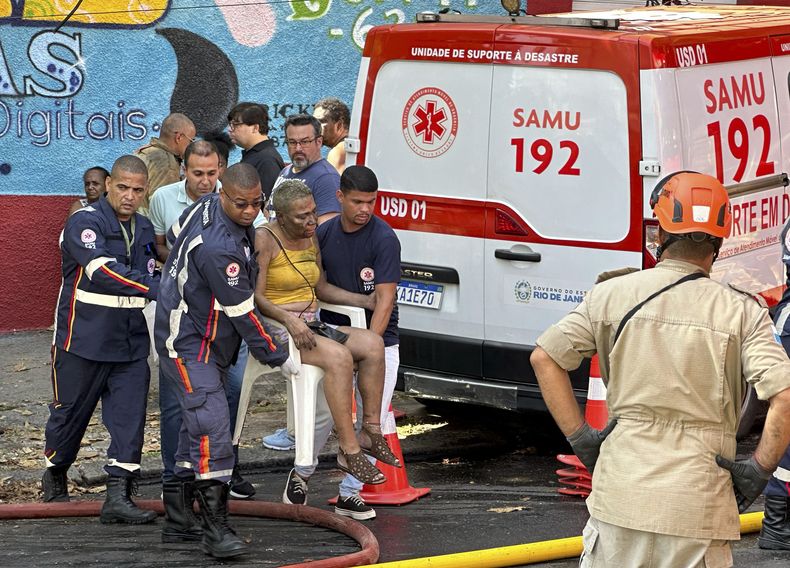 Personal de salud lleva a una mujer herida después de que un incendio destruyera una fábrica que produce trajes de Carnaval para las escuelas de samba de la división inferior en Río de Janeiro, el miércoles 12 de febrero de 2025. (AP Foto/Diarlei Rodrigues)