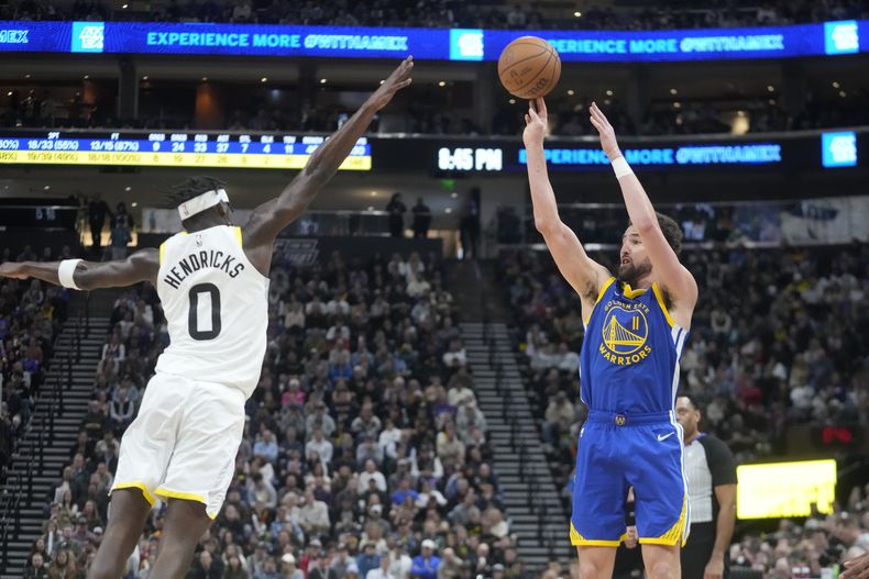 Klay Thompson, de los Warriors de Golden State, intenta un triple frente a Taylor Hendricks, del Jazz de Utah, el jueves 15 de febrero de 2024 (AP Foto/Rick Bowmer)