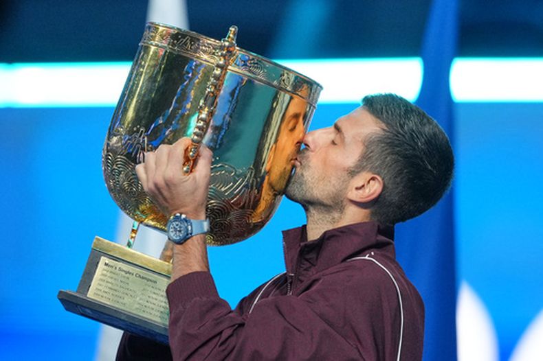 Novak Djokovic besa el trofeo tras proclamarse campeón del Abierto de China, el martes 6 de octubre de 2026, en Beijing. (AP Foto/Achmad Ibrahim)