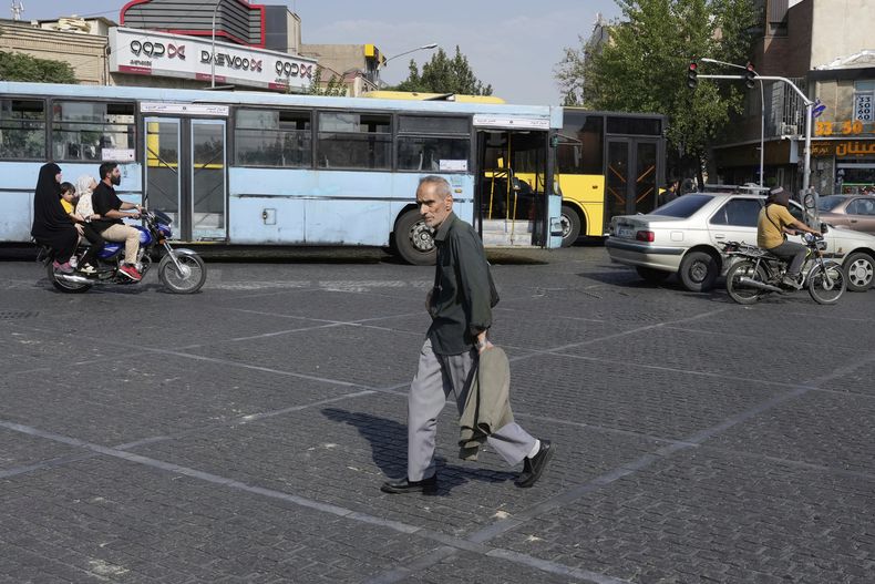 Un hombre cruza una intersección en un caluroso día de verano en el centro de Teherán, Irán, el lunes 21 de julio de 2025. (AP Foto/Vahid Salemi)