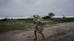 Un hombre camina bajo la lluvia antes de la llegada del huracán Melissa, en Canizo, una localidad en Santiago de Cuba, el 28 de octubre de 2025. (AP Foto/Ramón Espinosa)