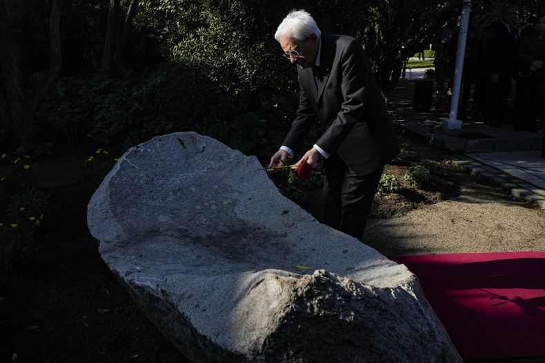 El presidente italiano, Sergio Mattarella, coloca una flor en un monumento en honor a Lumi Videla, una mujer que fue asesinada durante la dictadura del general Augusto Pinochet, en Santiago, Chile, el miércoles 5 de julio de 2023. Videla fue detenida el 21 de septiembre de 1974 y no se supo nada de ella hasta la madrugada del 4 de noviembre, cuando su cuerpo fue arrojado por encima del muro hacia el interior de la embajada italiana en la capital chilena, donde se habían refugiado cientos de chilenos. (AP Foto/Esteban Félix)