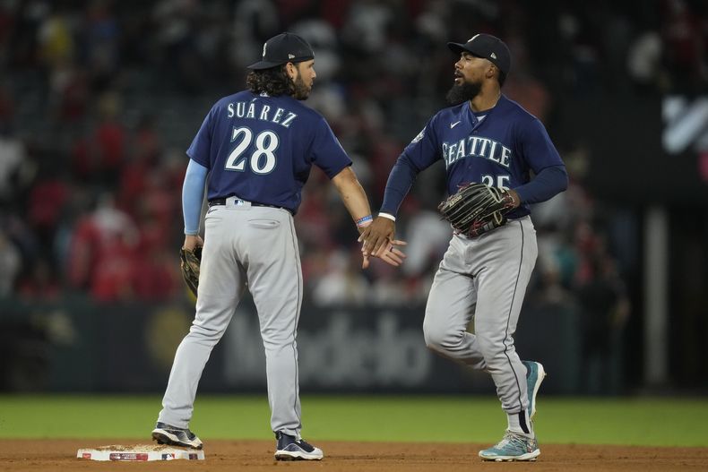 El venezolano Eugenio Suárez y su compañero Dylan Moore festejan el triunfo sobre los Angelinos de Los Ángeles, el viernes 4 de agosto de 2023 (AP Foto/Ashley Landis)
