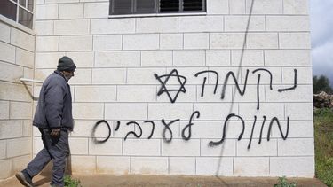 Un hombre pasa frente a una pared con un graffiti que dice en hebreo venganza, muerte a los árabes, supuestamente pintado por colonos judíos en la aldea palestina de Turmus Ayya, en Cisjordania, el 18 de febrero de 2024. (Foto AP/Nasser Nasser, Archivo)