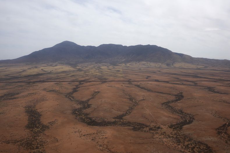 Un helicóptero Blackhawk del ejército de Estados Unidos vuela cerca de la frontera con México dentro de la Fuerza de Tarea Conjunta Frontera Sur el jueves 3 de abril de 2025, en Douglas, Arizona. La línea del muro fronterizo puede verse a la mitad de la foto. (AP Foto/Ross D. Franklin)