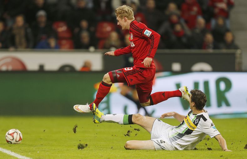 Julian Brandt, del Bayer Leverkusen, elude a Roel Brouwers, del Borussia Moenchengladbach, durante un encuentro de la liga alemana disputado el domingo 14 de diciembre de 2014 (AP Foto/Frank Augstein)