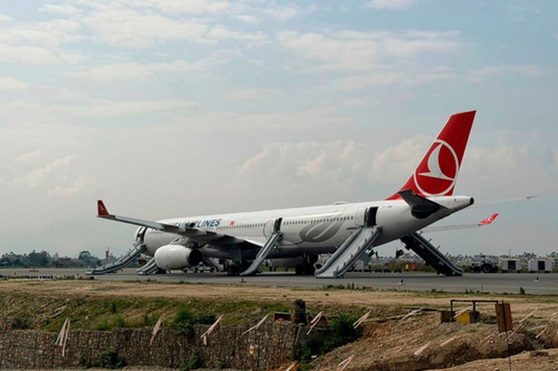 Un avión de Turkish Airlines después de que los pasajeros fueron evacuados y el aeropuerto principal de Nepal fue cerrado luego de un incendio en el tren de aterrizaje de la aeronave, el lunes 11 de mayo de 2026, en Katmandú. (AP Foto/Rajneesh Bhandari)