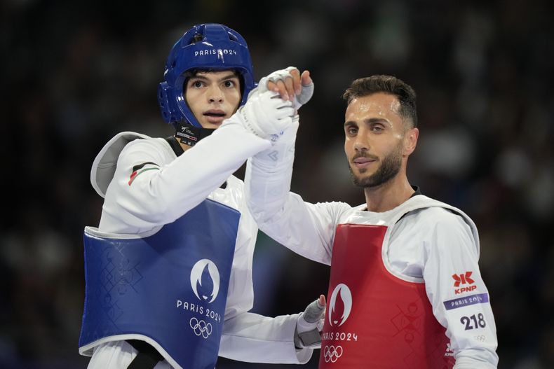 El palestino Omar Yaser Ismail, de azul, compite contra Hadi Tiranvalipour, del equipo olímpico de refugiados en el combate de los 58 kilogramos de taekwondo de los Juegos Olímpicos, el miércoles 7 de agosto de 2024, en París. (AP Foto/Andrew Medichini)