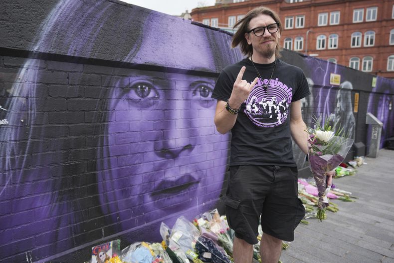 El fan Matthew Caldwell sostiene flores para conmemorar la muerte de Ozzy Osbourne en Birmingham, el miércoles 23 de julio de 2025. (Foto AP/Kin Cheung)