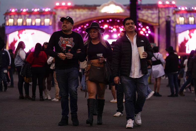 Personas caminan cerca de un escenario en el festival Arre en la Ciudad de México el domingo 8 de septiembre de 2024. (Foto AP/Felix Marquez)