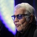 ARCHIVO - El diseñador de moda italiano Roberto Cavalli responde a las preguntas de un reportero de televisión antes del inicio del desfile de la colección para damas Primavera-Verano 2014 de Just Cavalli, parte de la Semana de la Moda de Milán, presentado en Milán, Italia, el 19 de septiembre de 2013. Cavalli, conocido por su estilo extravagante y glamoroso, murió el viernes 12 de abril de 2024 a los 83 años, anunció su compañía en una publicación de Instagram. (Foto AP/Luca Bruno, archivo)
