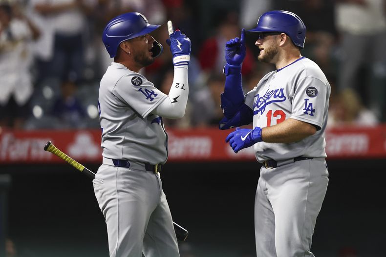 Max Muncy, derecha, de los Dodgers de Los Ángeles, celebra con Miguel Rojas, izquierda, después de que Muncy bateara un cuadrangular durante la octava entrada del juego de béisbol en contra de los Angelinos de Los Ängeles, el lunes 11 de agosto de 2025, en Anaheim, California. (AP Foto/Jessie Alcheh)
