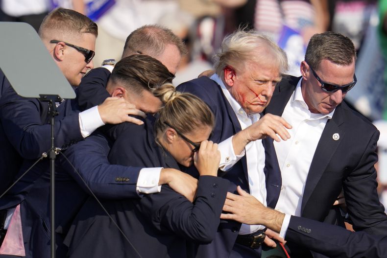 Agentes del Servicio Secreto se llevan al candidato presidencial republicano Donald Trump del escenario tras recibir un disparo durante un acto de campaña, el 13 de julio de 2024, en Butler, Pensilvania. (AP Foto/Gene J. Puskar)