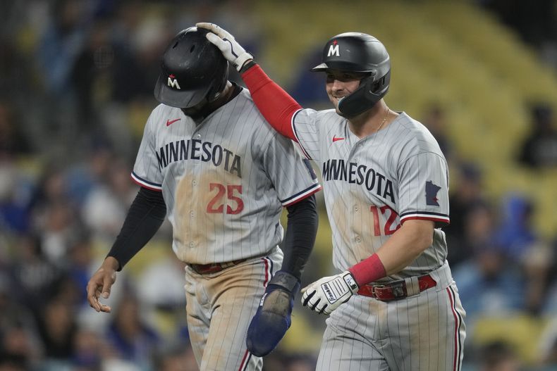 Kyle Farmer, de los Mellizos de Minnesota, festeja con su compañero Byron Buxton, luego de remolcarlo con un jonrón en el duelo del martes 16 de mao de 2023, ante los Dodgers de Los Ángeles (AP Foto/Ashley Landis)