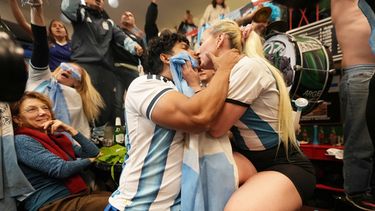 Una pareja de hinchas de Argentina se besa tras la victoria ante Inglaterra en las semifinales del Mundial, el miércoles 15 de julio de 2026, en Buenos Aires. (AP Foto/Rodrigo Abd)