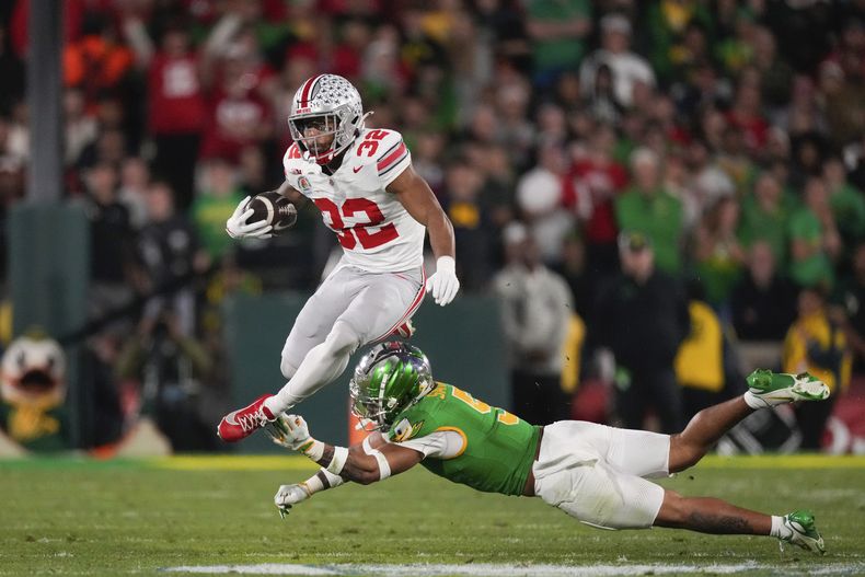 TreVeyon Henderson, corredor de Ohio State, elude a Kobe Savage, de Oregon, en el Rose Bowl, el miércoles 1 de enero de 2025 en Pasadena, California (AP Foto/Mark J. Terrill)
