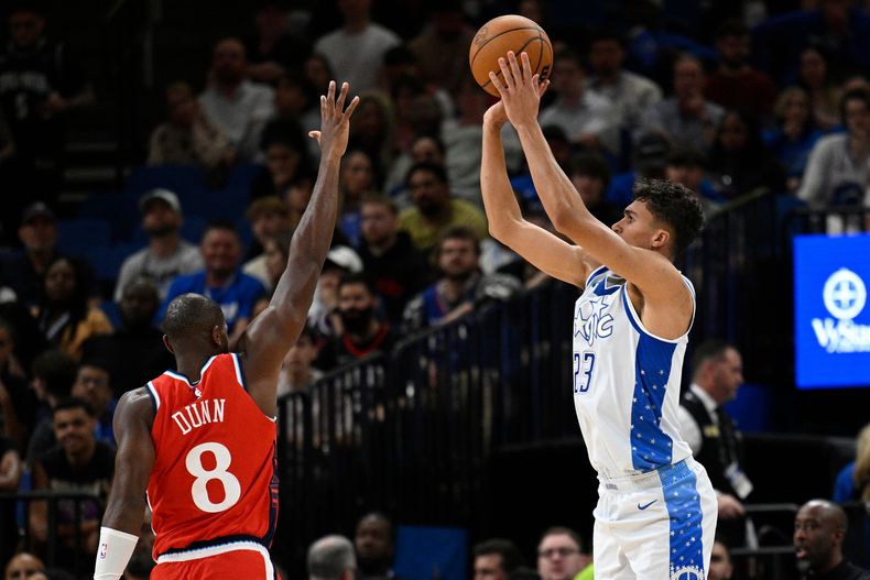 Tristan da Silva, alero del Magic de Orlando, dispara un triple ante Kris Dunn, de los Clippers de Los Ángeles, en el duelo del jueves 20 de noviembre de 2025 (AP Foto/Phelan M. Ebenhack)