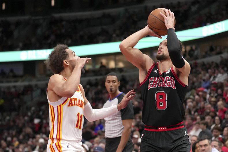 Zach LaVine (8), de los Bulls de Milwaukee, tira mientras Trae Young, de los Hawks de Atlanta, defiende durante la segunda mitad del juego de baloncesto de la NBA Cup, el viernes 22 de noviembre de 2024, en Chicago. (AP Foto/Charles Rex Arbogast)