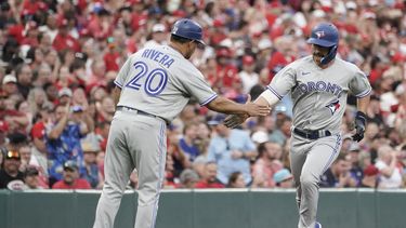 Davis Schneider, de los Azulejos de Toronto, festeja con el coach de tercera Luis Rivera luego de conectar un jonrón en el juego del sábado 19 de agosto de 2023, ante los Rojos de Cincinnati (AP Foto/Joshua A. Bickel)