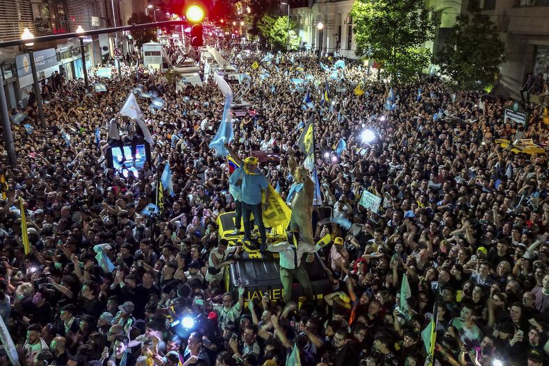 Partidarios del candidato presidencial Javier Milei celebran afuera de su sede de campaña su victoria sobre el ministro de Economía, Sergio Massa, candidato del gobernante peronismo, en la segunda vuelta presidencial en Buenos Aires, Argentina, el domingo 19 de noviembre de 2023. (AP Foto/Matias Delacroix)