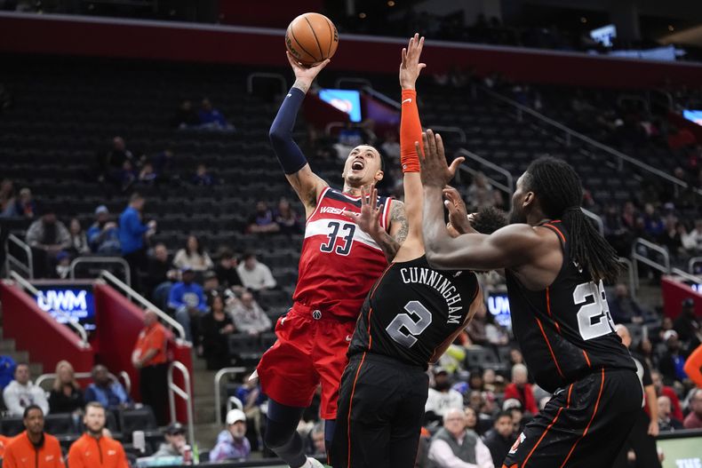 El alero de los Wizards de Washington Kyle Kuzma avanza hacia la canasta mientras lo defiende el base de los Pistons de Detroit Cade Cunningham en el encuentro de la NBA del sábado 27 de enero del 2024. (AP Foto/Paul Sancya)